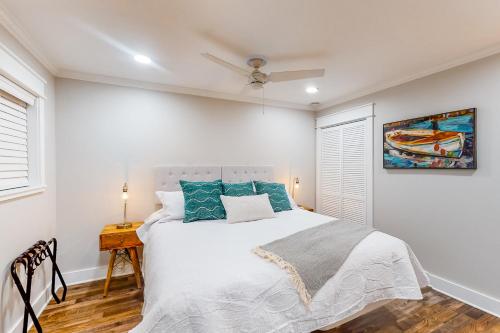 a white bedroom with a bed and a painting on the wall at Hilton Head Beach & Tennis Unit B222 in Hilton Head Island