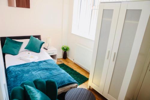 a bedroom with a bed with green pillows at CHATHAM GUEST HOUSE in Chatham