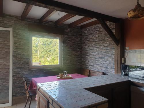 une cuisine avec une table et une fenêtre dans l'établissement White wood, à Darney