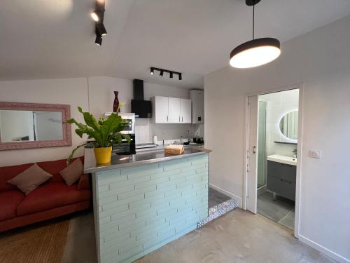 a kitchen and living room with a red couch at Le Patio d’Eymet in Eymet