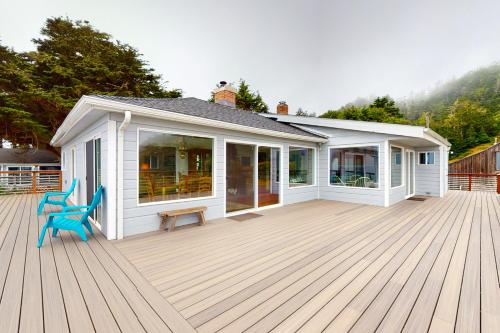 a white house with a deck with two chairs at Saddle Point Estate in Elk
