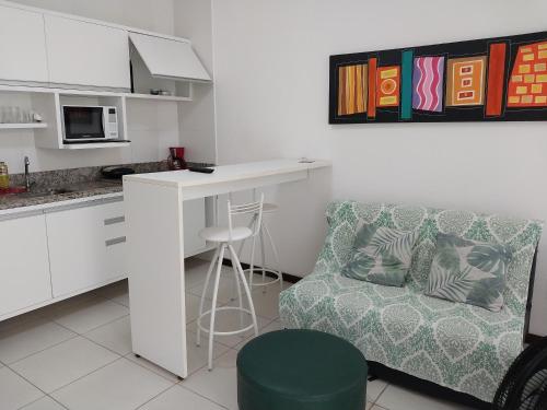 a living room with a couch and a table and a kitchen at Serena Morro in Morro de São Paulo