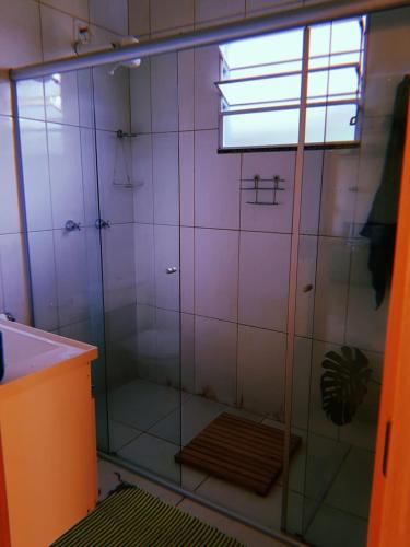 a shower with a glass door in a bathroom at Abrigo Serafina#cama&café in Itamonte