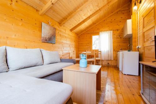 ein Wohnzimmer mit einem Sofa und einem Tisch in der Unterkunft KATANA VILLAGE APARTMENT in Ulcinj