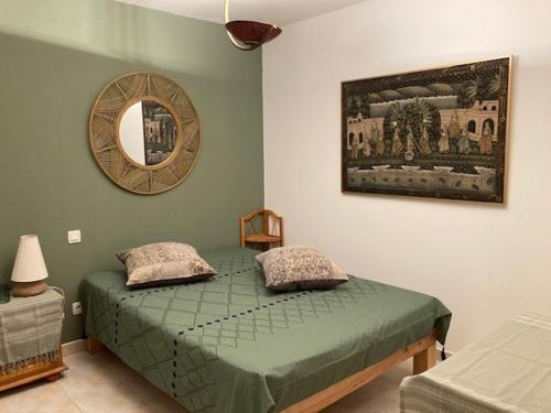 um quarto com uma cama verde e um espelho em Villa Nova Raï du Mas des Fontaines - Jardin, piscine, terrasses 4 à 6 pers em Montagnac