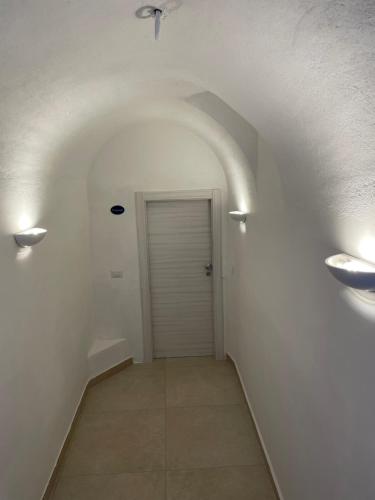 a hallway with white walls and a door with lights at Villa Pino in Furore