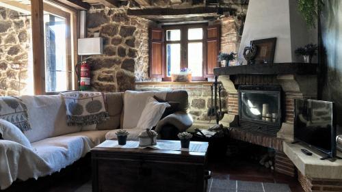 a living room with a couch and a fireplace at Casa familia La Casa de Quintanilla 2 in Aguilar de Campóo