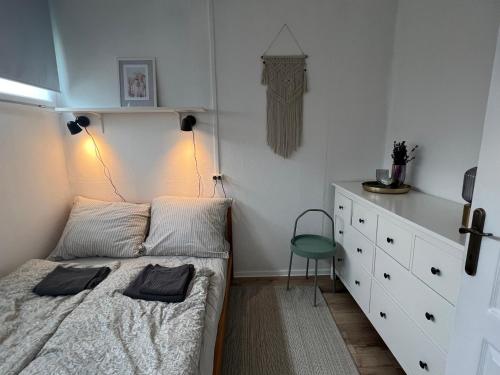 a small bedroom with a bed and a dresser at Bánhiday M4 Weekendhouse in Balatonakarattya