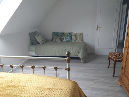 a bedroom with a bed and a couch in a room at Maison avec jardin clos dans cité de caractère in La Roche-Derrien