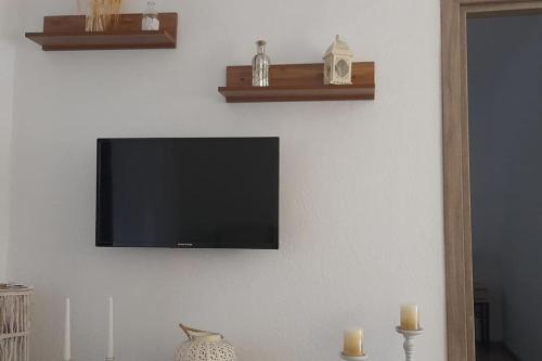 a flat screen tv hanging on a white wall at 4 Season Cozy Home in Samothráki