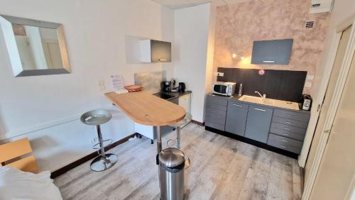 ロアンヌにあるAppart hôtel Roanne hyper centre villeの小さな客室で、キッチン(テーブル、シンク付)が備わります。