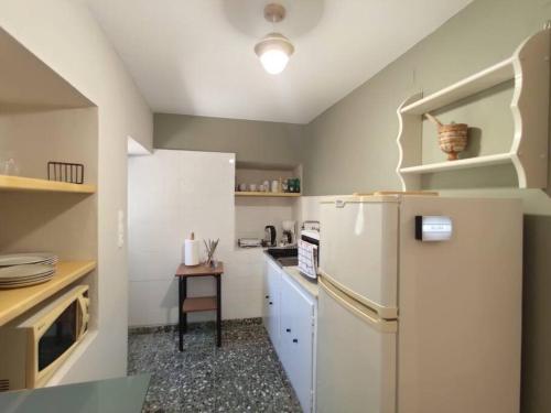 ガリッサスにあるVillage View Houseの白い冷蔵庫とテーブルのあるキッチン