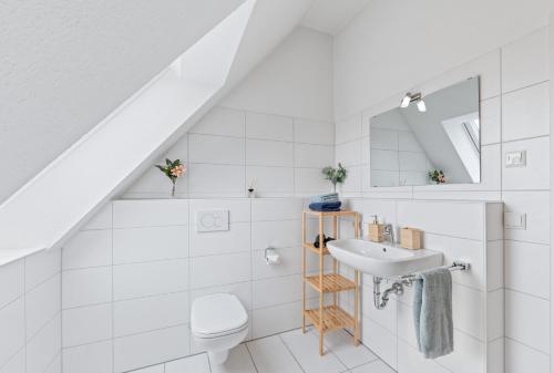 biała łazienka z umywalką i toaletą w obiekcie Design-Apartment - Küche - Balkon - Tiefgarage w mieście Leinfelden-Echterdingen