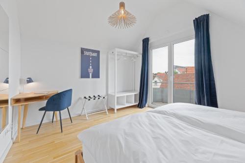 biała sypialnia z biurkiem i łóżkiem w obiekcie Design-Apartment - Küche - Balkon - Tiefgarage w mieście Leinfelden-Echterdingen