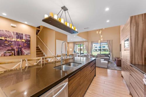 a kitchen with a sink and a living room at 7594 Magic Village 3suites 6guets 8 min Disney in Orlando