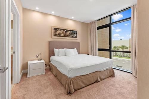 a bedroom with a bed and a large window at 7594 Magic Village 3suites 6guets 8 min Disney in Orlando