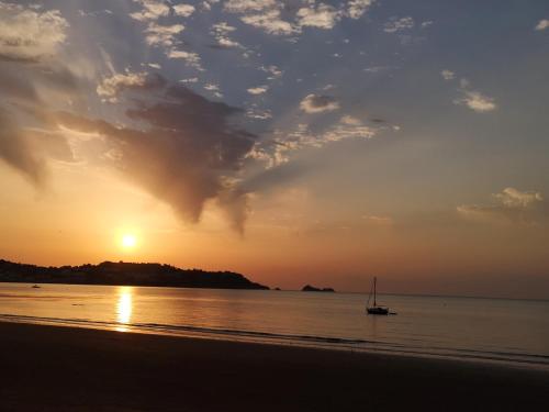 a boat in the water on a beach at sunset at Sea Shells in Torquay