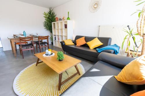 uma sala de estar com um sofá e uma mesa em Le Royal 4* – Grand Confort Salle de Sport privée em Vandoeuvre-lès-Nancy