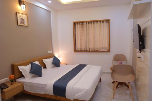 TaliparambaにあるV.A TOURIST RESIDENCYのベッドと椅子とテレビのある寝室