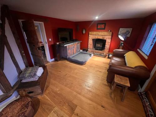 a living room with a couch and a fireplace at Hound and Human Holiday Cottage - Redgrave, Suffolk in Diss