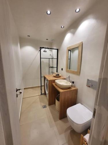 a bathroom with a toilet and a sink and a mirror at Coucou Boutique Studio in Ios Chora