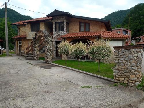 Vila Nenad Ovčar banja في تشاتشاك: منزل بحائط حجري امام ممر