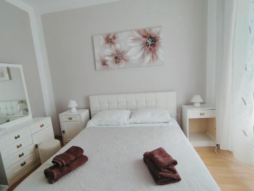 een witte slaapkamer met een bed met twee handdoeken erop bij Fami Superior One Bedroom Apartment in Rijeka