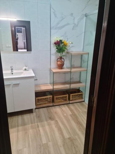 a bathroom with a sink and a vase of flowers at Allotjament dels Ports in La Senia