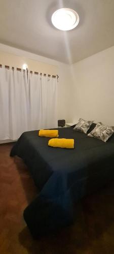 a bedroom with a bed with yellow pillows on it at Departamento en Capital in Mendoza