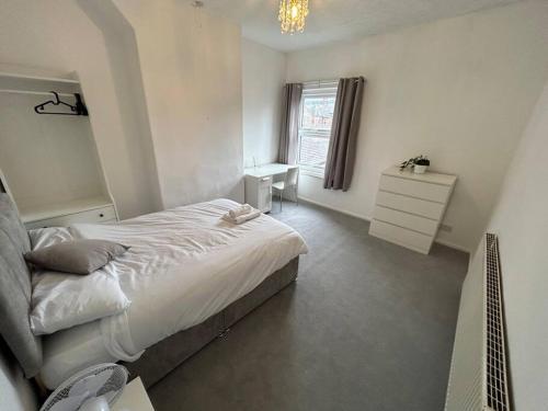 Etruria的住宿－Perfect Home From Home In Stoke on Trent，一间卧室配有一张床、一张书桌和一个窗户。
