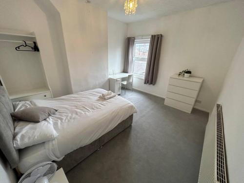 a bedroom with a bed and a desk and a window at Perfect Home From Home In Stoke on Trent in Etruria
