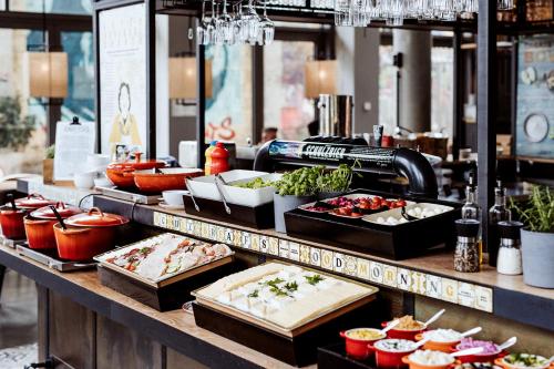 a buffet line with different types of food on display at Emma by Schulz Hotel Berlin Friedrichshain in Berlin