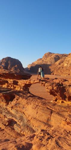 Deux personnes debout sur un rocher dans le désert dans l'établissement Bedouin experiences, à Aqaba