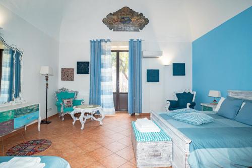 a blue bedroom with a bed and a table at Castle Living in Catania