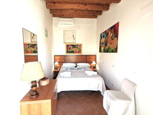 a bedroom with a bed and a desk with a lamp at La Casa Delle Fate in Siracusa