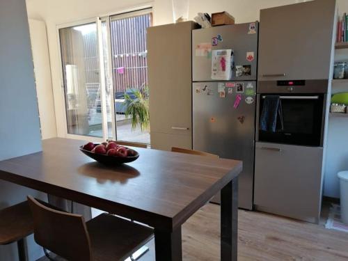 une cuisine avec une table avec un bol de fruits dessus dans l'établissement Attique vue mer et campagne, la plage à pied, à Saint-Jean-de-Luz