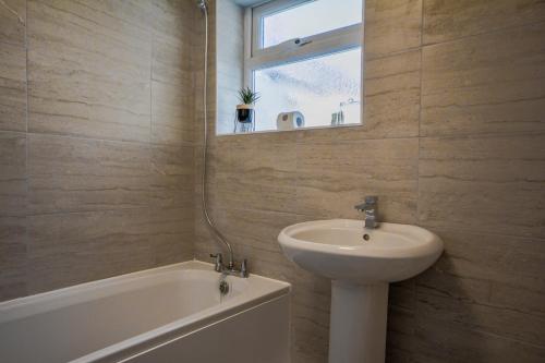 a bathroom with a sink and a bath tub and a mirror at Stay with Alexandra in Liverpool