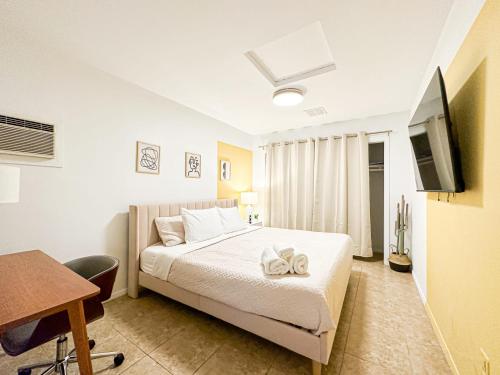 um quarto com uma cama, uma secretária e uma televisão em Charming 1 BR Poolside Retreat - Lou2-Bur em Burbank