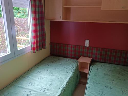 mały pokój z 2 łóżkami i oknem w obiekcie En Saubis 