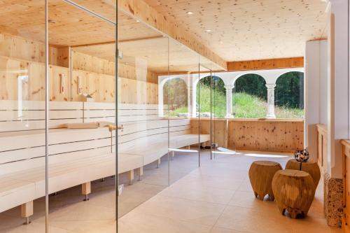 Łazienka ze szklanymi ścianami i drewnianą podłogą w obiekcie Hotel Lärchenhof Natur w mieście Seefeld in Tirol