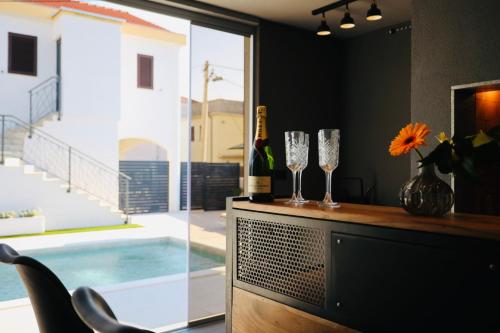 a room with a bar with wine glasses and a pool at Holiday Home TiA in Split
