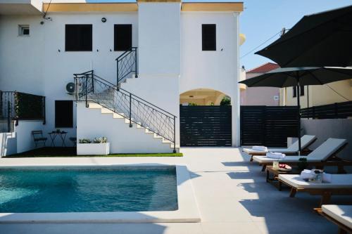 una casa con piscina al lado de un edificio en Holiday Home TiA, en Split