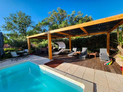 um pátio com uma piscina e uma pérgola de madeira em Domaine à l'Aise em Plaissan