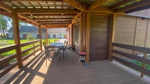 a wooden porch with a table and chairs on it at Siedlisko Rozalin in Rozalin