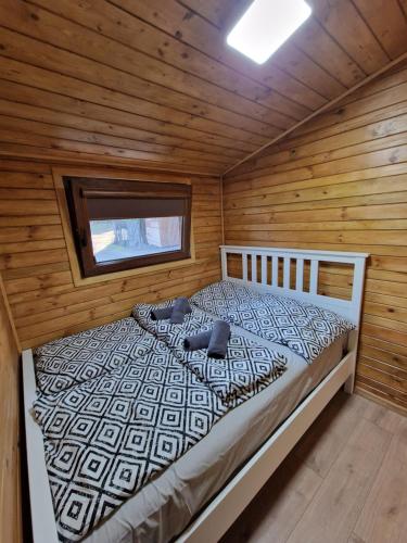 1 dormitorio con 1 cama en una cabaña de madera en Domek letniskowy na Łowisku Muławki en Kętrzyn