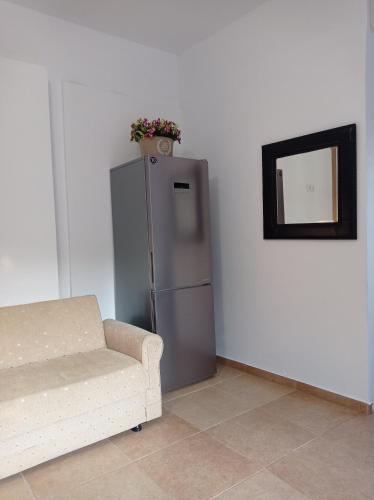 a living room with a couch and a refrigerator at KOLLITAKI in Selínia