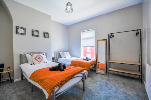 a bedroom with two beds and a mirror at Stay with Alexandra in Liverpool