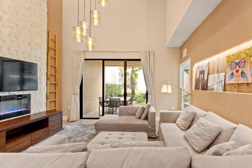 a living room with two couches and a tv at 7545 Magic Village 4 suites 8 guests 8 min Disney in Orlando