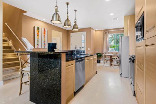 a kitchen with a black counter top and wooden cabinets at 7659 Magic Village Excellent 4 suites 6 min Disney in Orlando