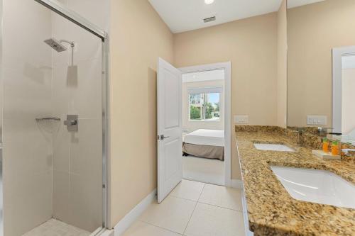 a bathroom with two sinks and a shower at 7659 Magic Village Excellent 4 suites 6 min Disney in Orlando